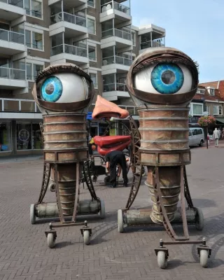 Kunstwerk van twee grote ogen, neus en lippen op een installatie van restmateriaal